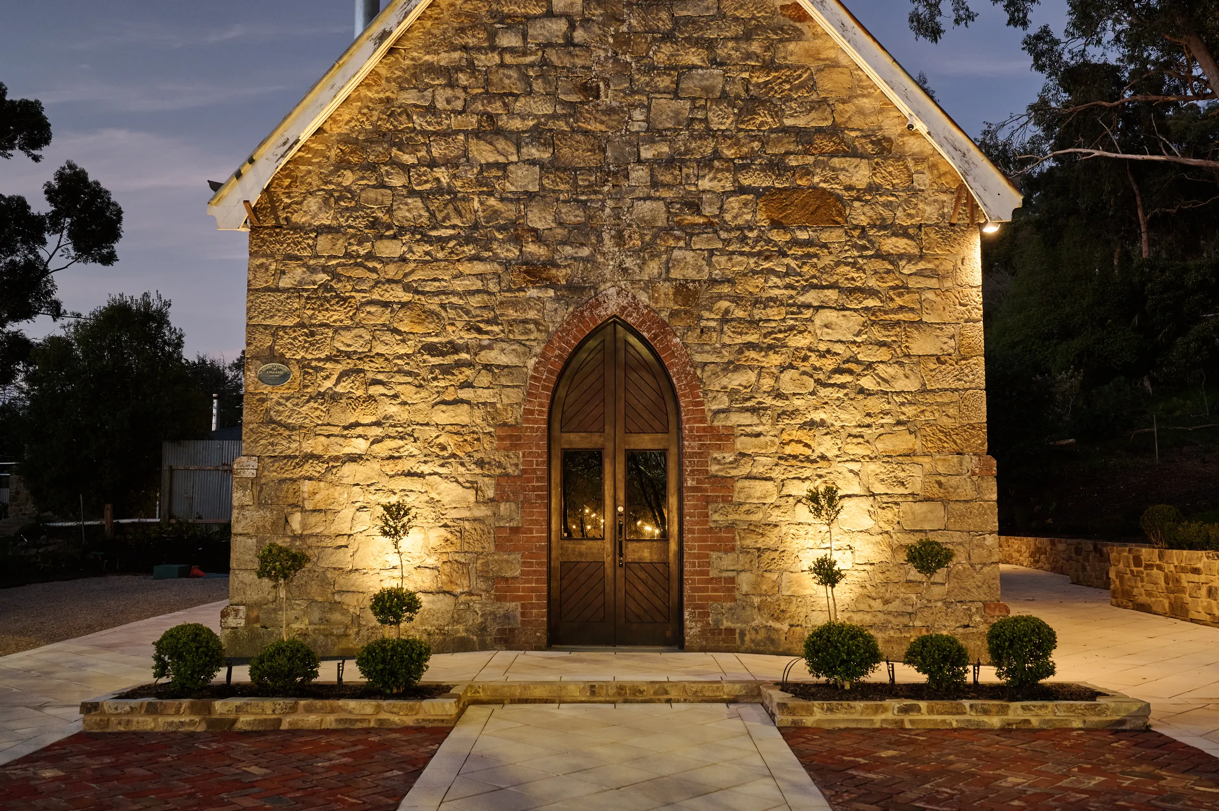 The stone facade of St. Stephen’s uplit at dusk, lights on inside